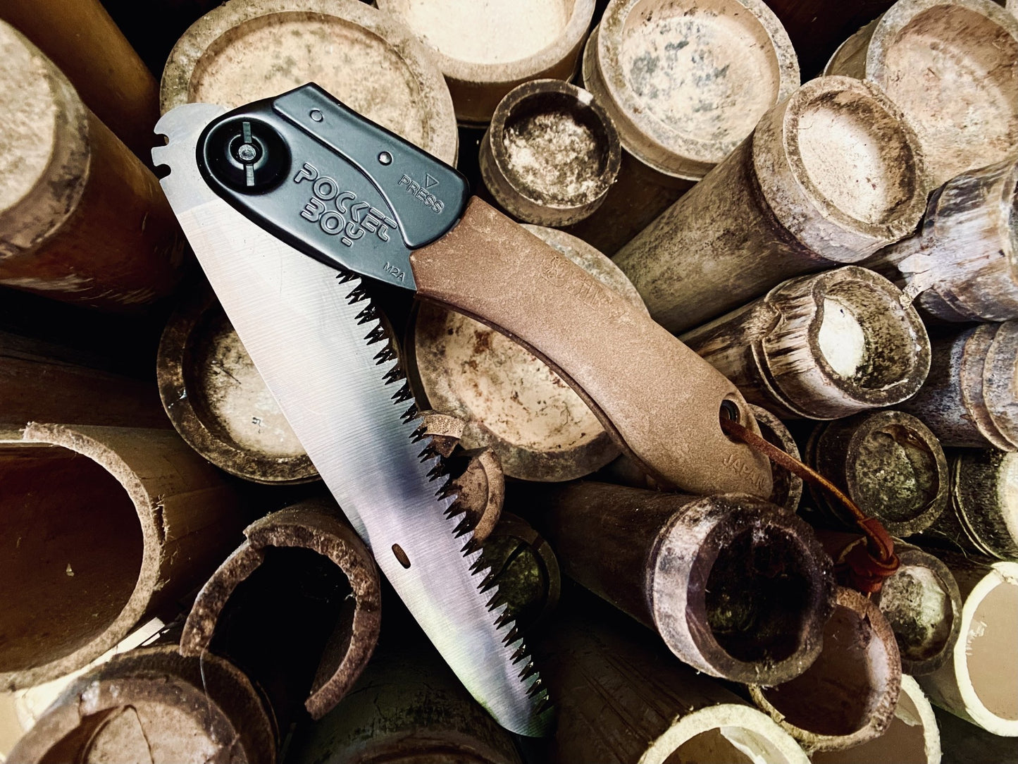 Silky PocketBoy Outback Edition Folding Saw: The Ultimate Outdoor Cutting Tool Half Open on Bamboo