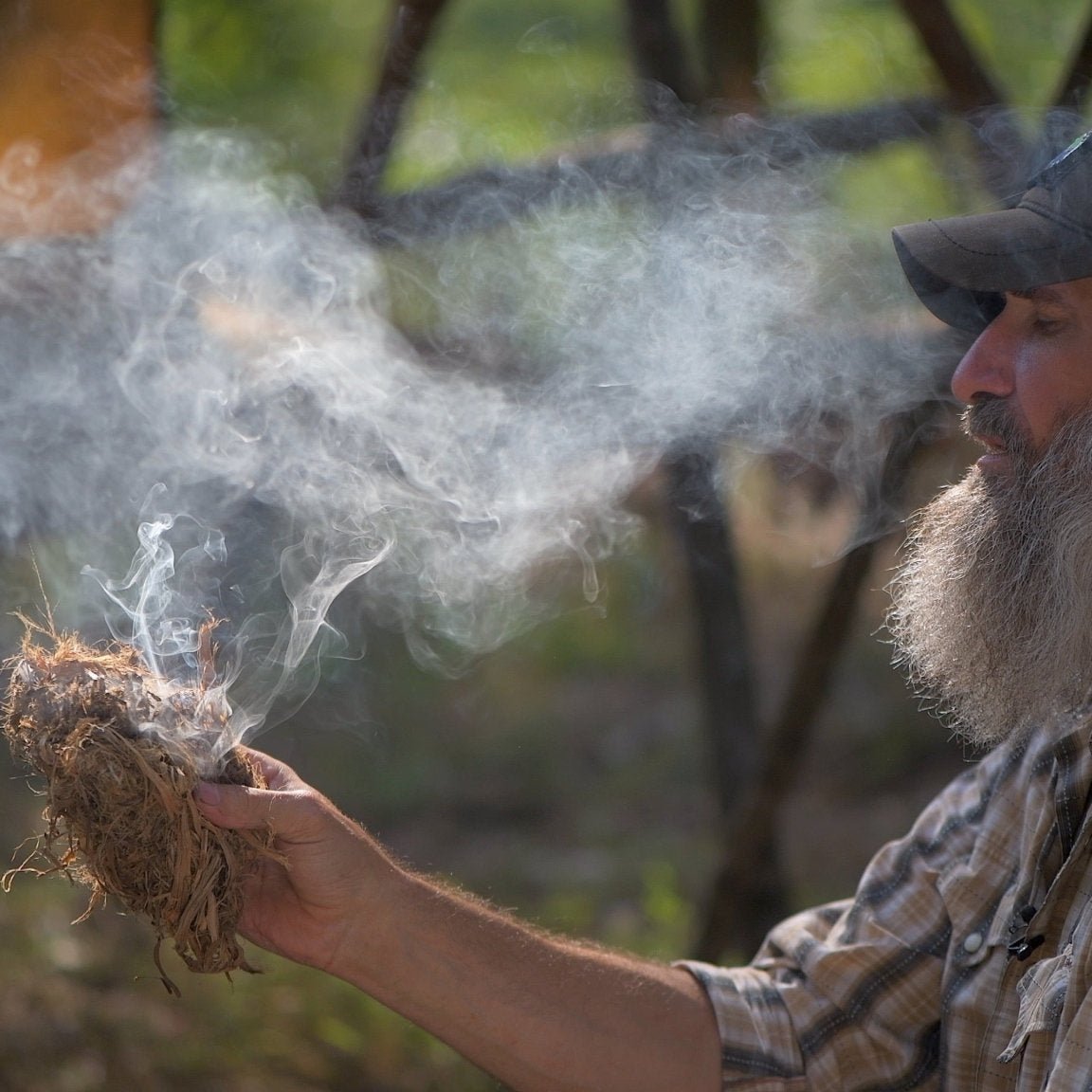 Survival Instructor Training and Certification Program - Gray Bearded Green Beret Survival School Instructor Teaching Blowing an Ember to Flame Solar and Friction Fire