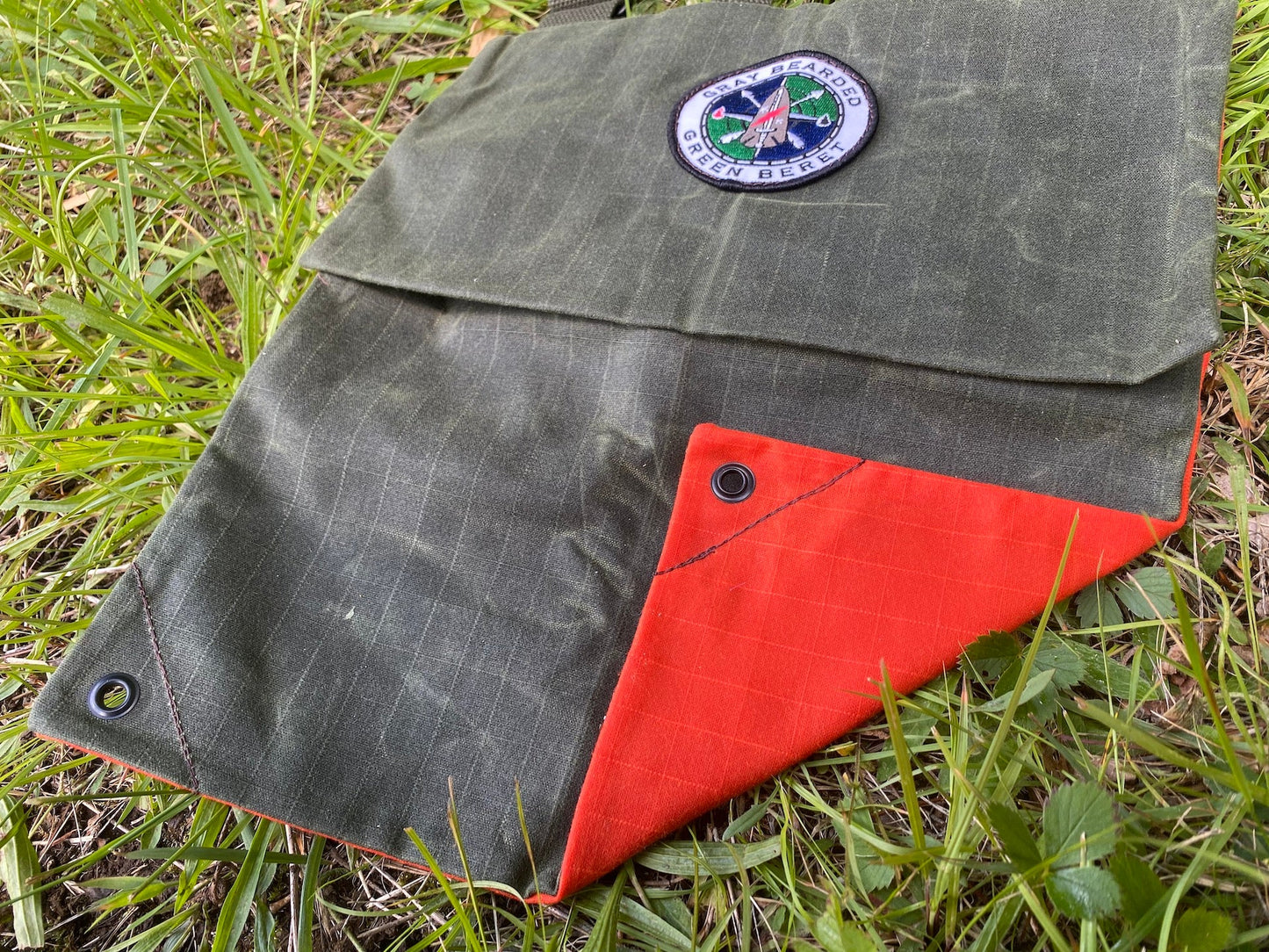 GB2 Waxed Canvas Haversack with Adjustable Strap Showing High-Visibility Orange Back Panel