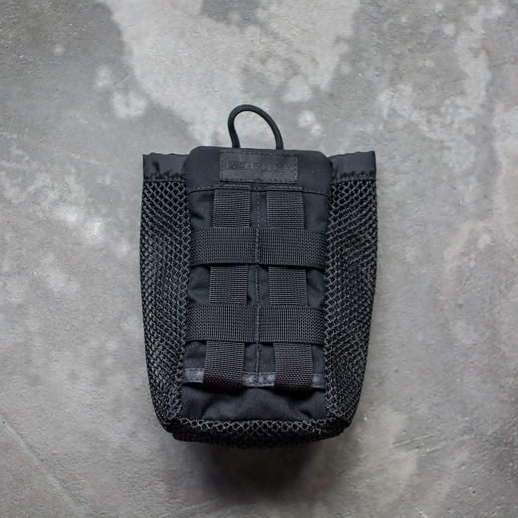Black GoRuck mesh water bottle pocket back view with a gray background