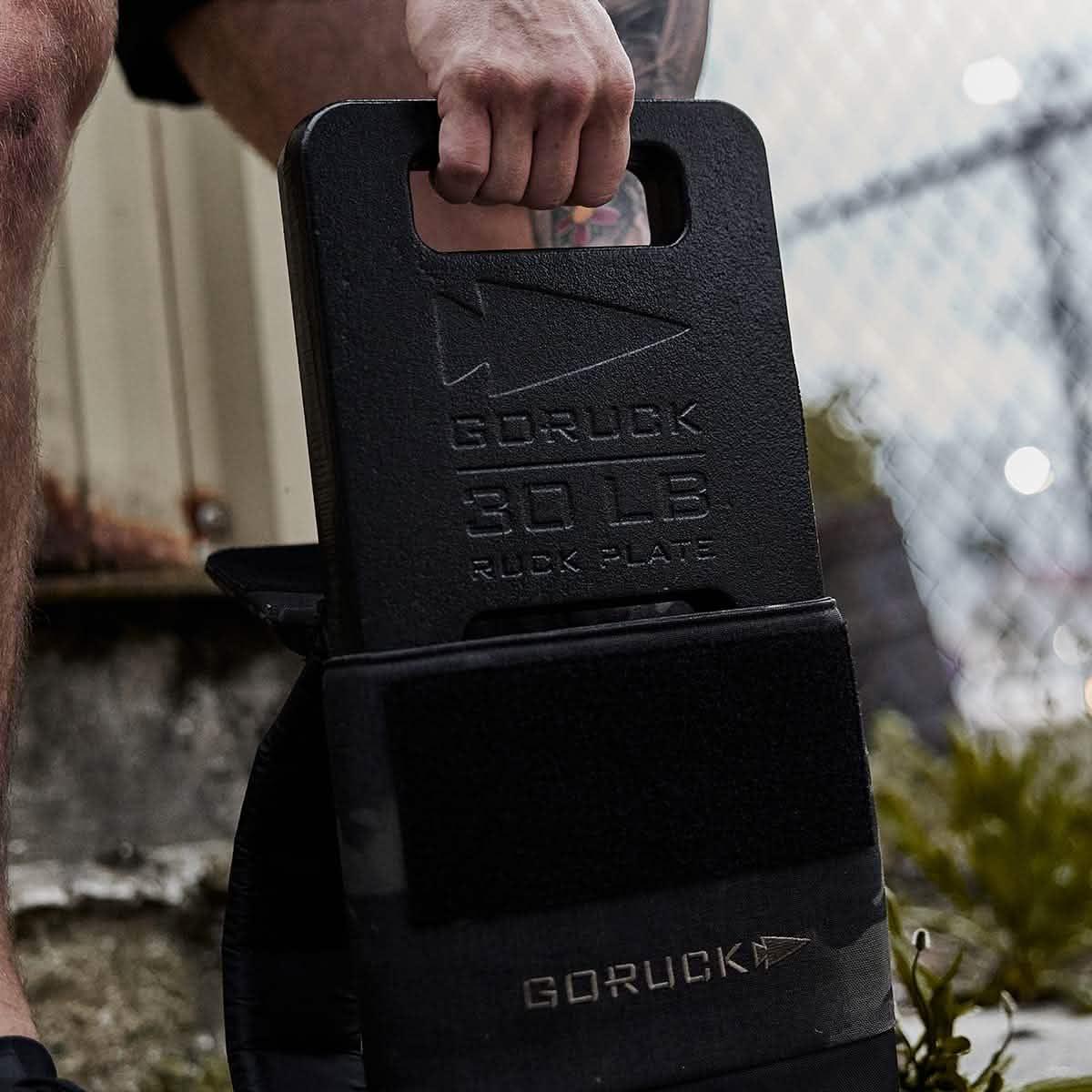 Man pulling GoRuck ruck plates out of a black ruck carrier