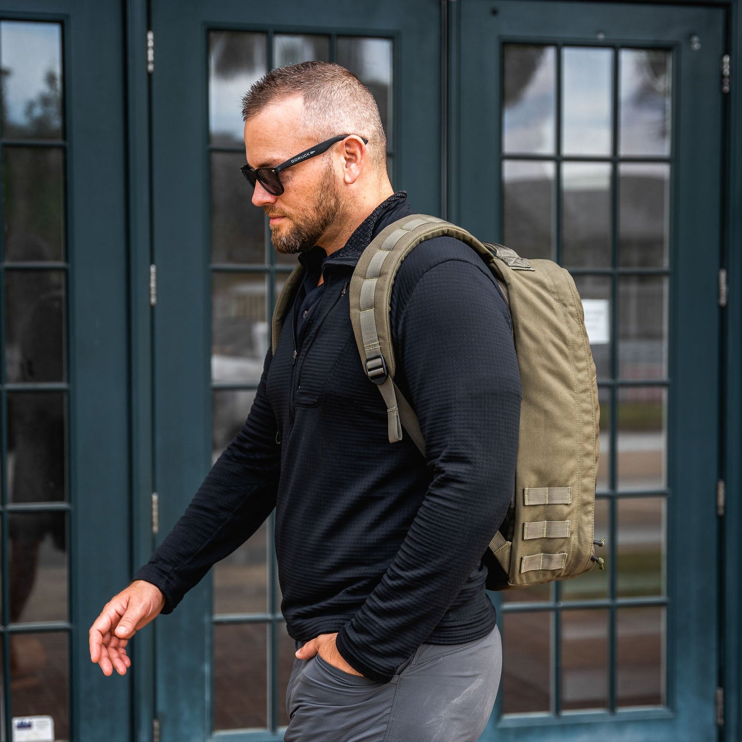 Man in an urban environment carrying a GoRuck rucksack