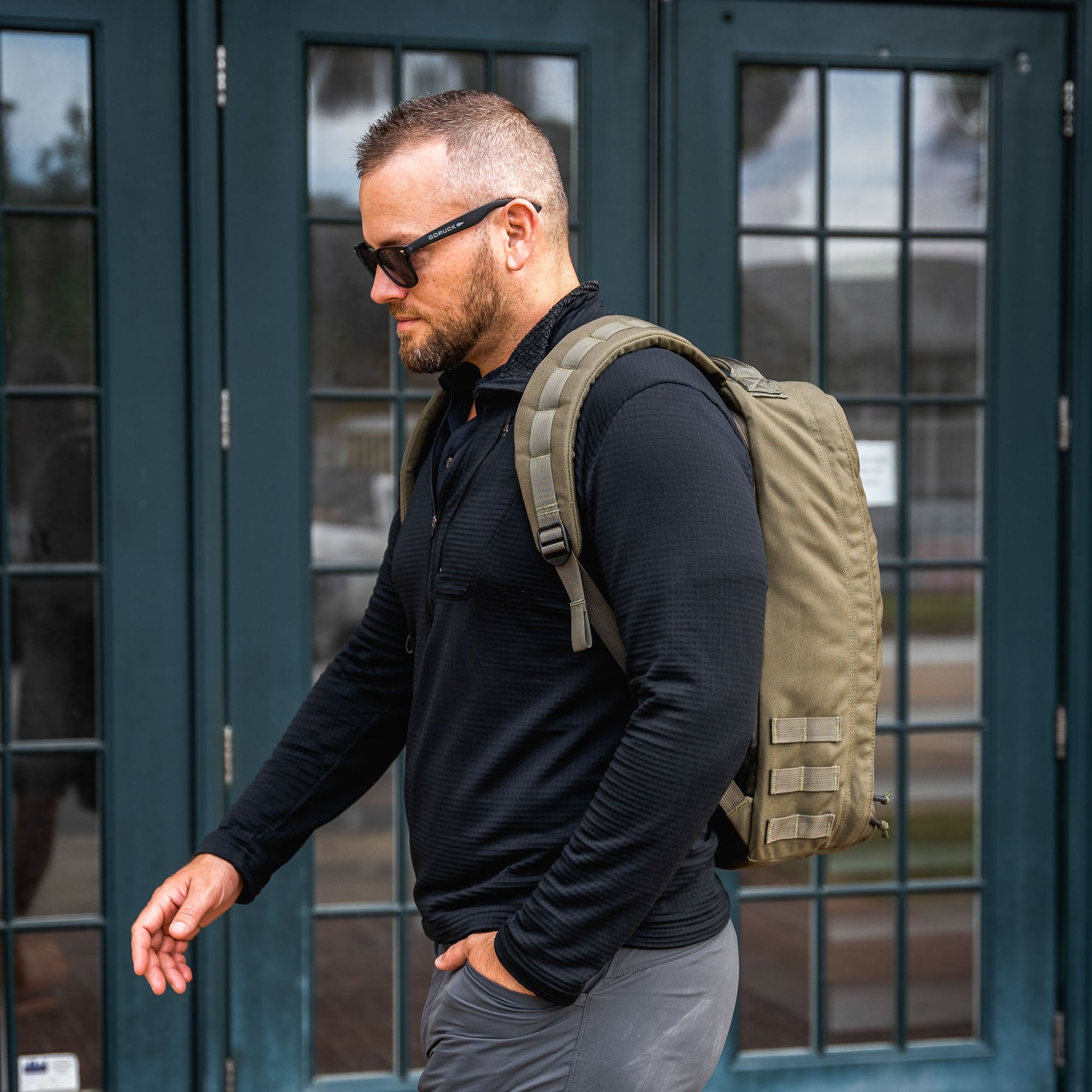 Man in an urban environment carrying a GoRuck rucksack