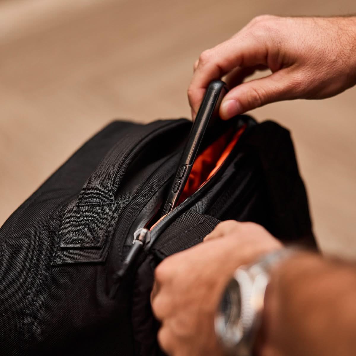 Cell phone being placed inside a GoRuck rucksack