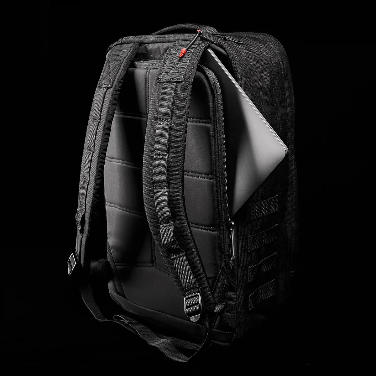 Black GoRuck rucksack with a laptop and a black background