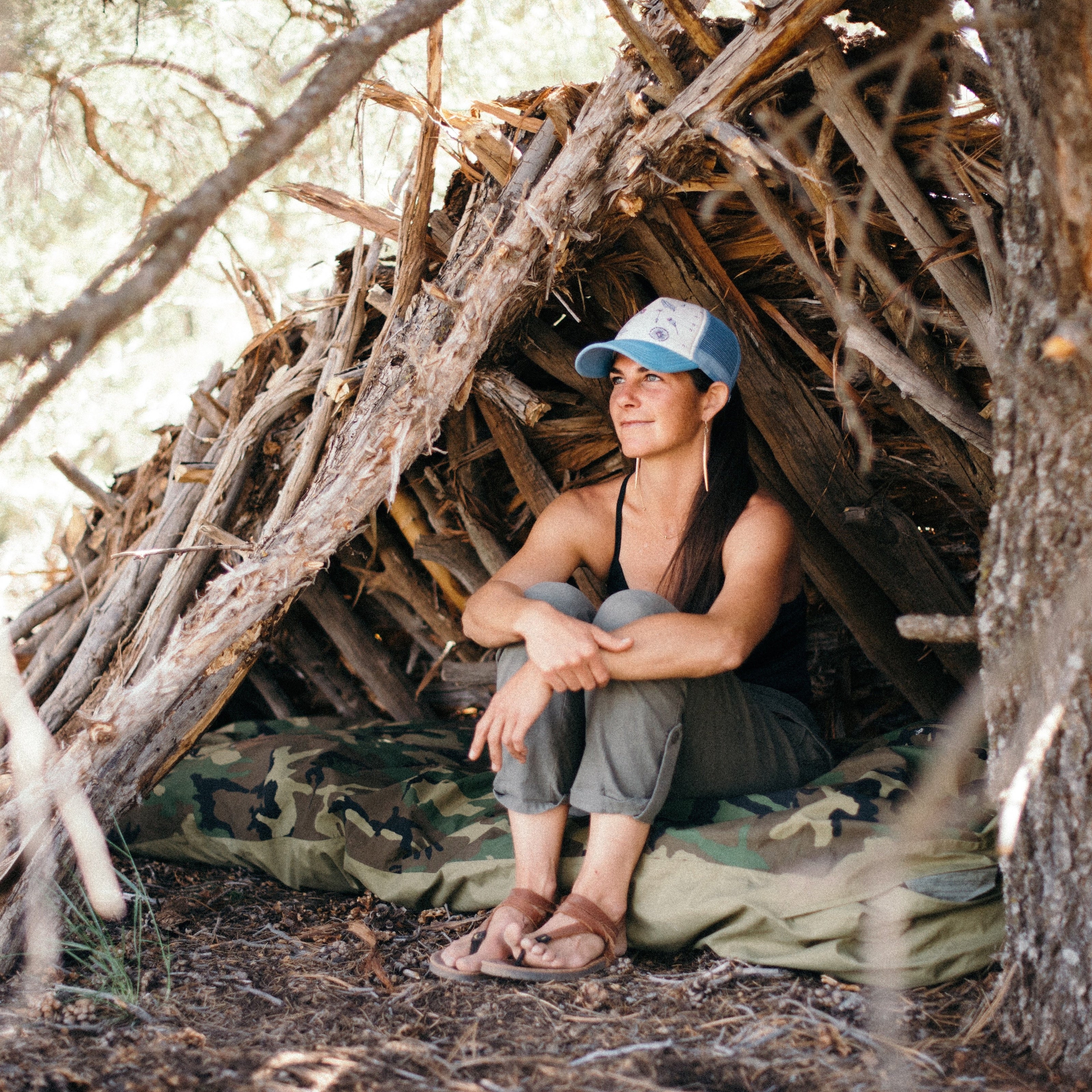 Person sitting inside a rustic wooden shelter in a natural setting