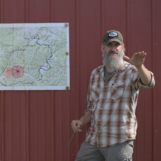 Man standing in front of a red building with a map on the wall