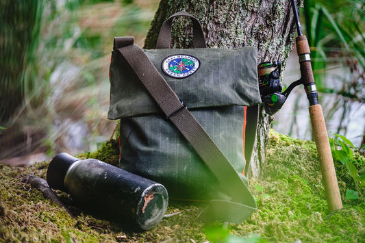 GB2 Waxed Canvas Haversack with Adjustable Strap with water bottle and fishing pole front