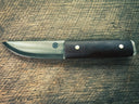 Knife with a brown micarta handle on a wooden surface