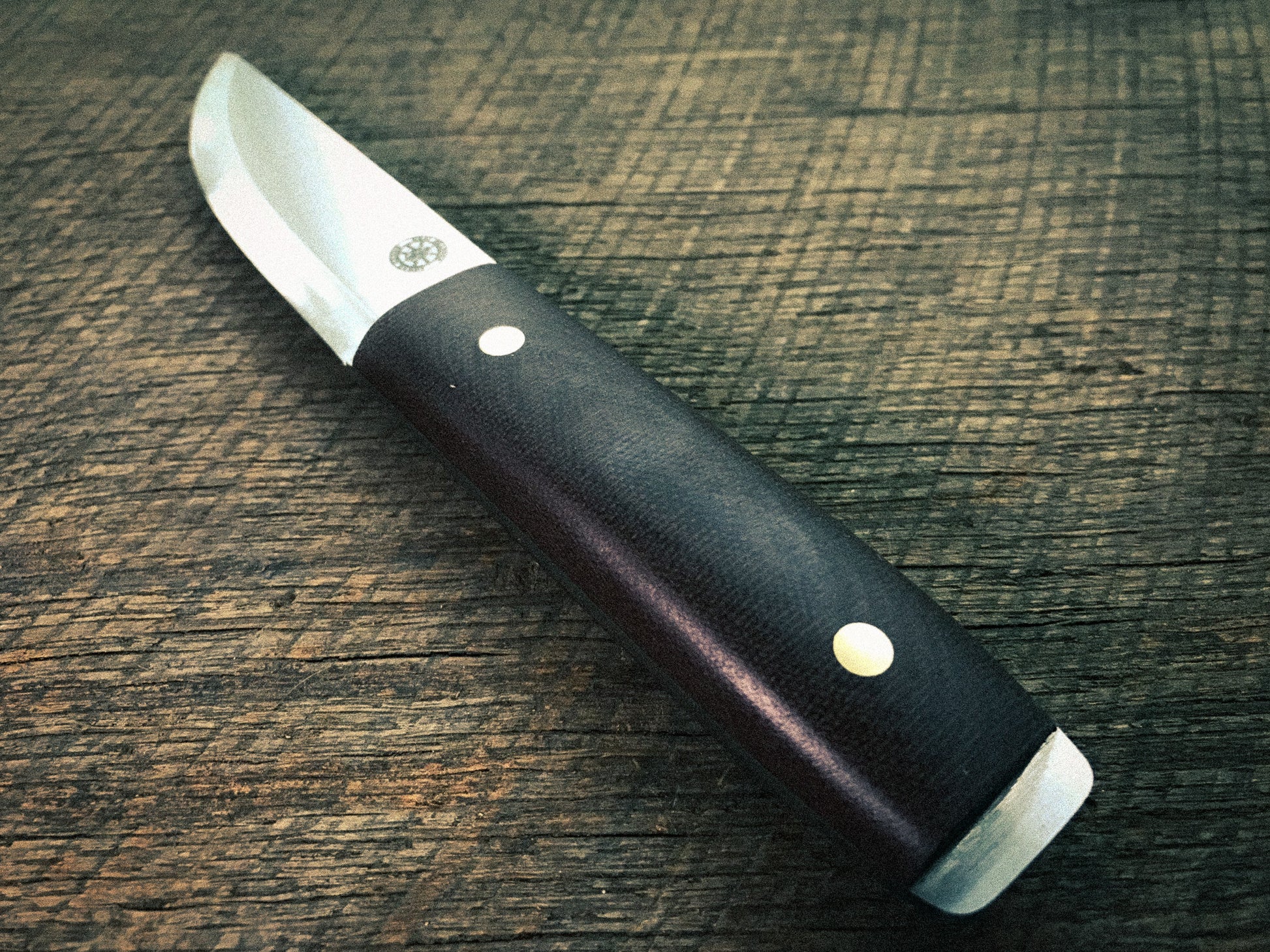 Knife with a brown handle on a wooden surface