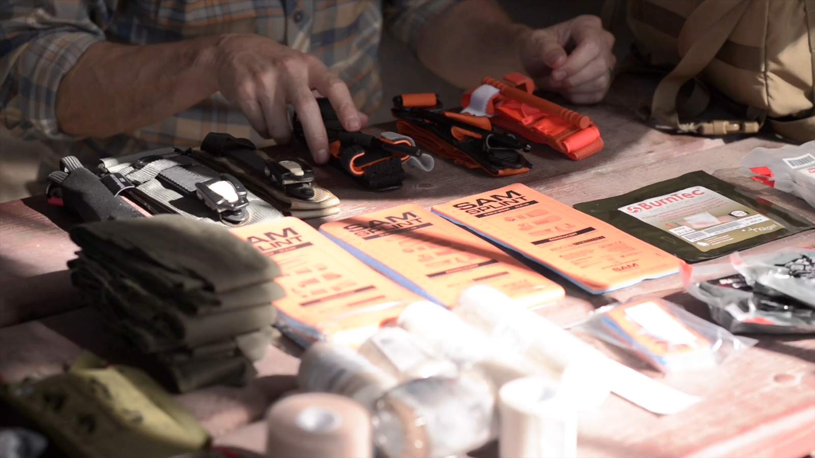 Wilderness first aid gear spread — SAM splints, tourniquets, and trauma supplies on field table