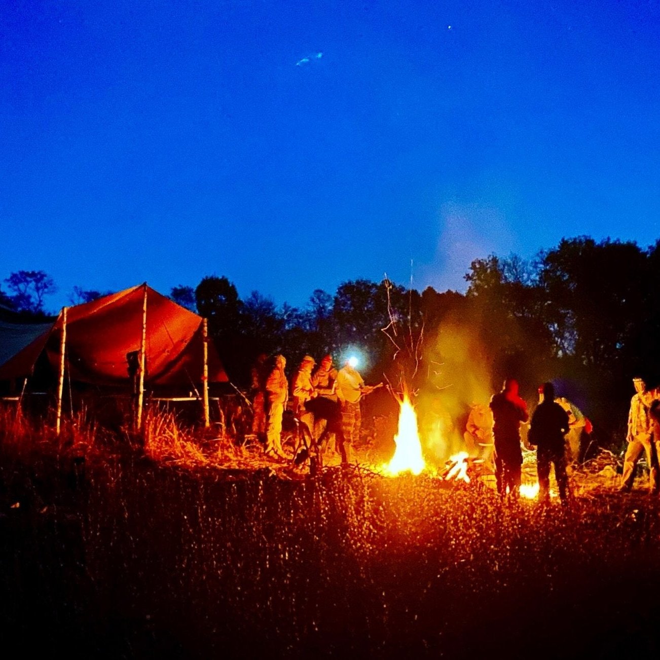 Wilderness Survival Course - Gray Bearded Green Beret Survival School - Students and Instructors around fire at night